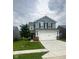Charming two-story home with a two-car garage, tree in the front yard, and light blue siding at 10835 Spirit Dr, Ingalls, IN 46048