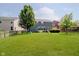 Well-maintained backyard featuring a lush lawn, mature trees, and outdoor seating area at 10962 Stoneleigh Dr, Noblesville, IN 46060
