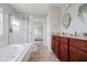 Bright bathroom with a soaking tub, glass shower, and double vanity with granite countertops at 10962 Stoneleigh Dr, Noblesville, IN 46060