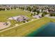 Aerial view of community pool, clubhouse, and playground next to a scenic pond at 10962 Stoneleigh Dr, Noblesville, IN 46060