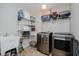 Well-equipped laundry room with modern washer and dryer, shelving, and utility sink at 10962 Stoneleigh Dr, Noblesville, IN 46060