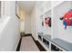 Convenient mudroom with built-in storage cubbies and a view of the hallway and bath at 10962 Stoneleigh Dr, Noblesville, IN 46060