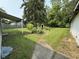 Large backyard featuring a covered porch, mature trees, and lush landscaping at 11026 N Kitchen Rd, Mooresville, IN 46158