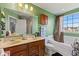 Bathroom with green walls, double sink vanity, large mirror, and tub/shower combo with curtain at 11614 Gosling Dr, Indianapolis, IN 46229