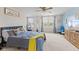 Bright main bedroom featuring a ceiling fan, two windows, blue accent wall and stylish decor at 11614 Gosling Dr, Indianapolis, IN 46229