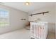 Bedroom with a crib, shelves, a large window, and neutral walls and floors at 1202 Orphant Annie, Greenfield, IN 46140