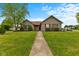 Charming single-story home with well-manicured lawn and inviting walkway at 1202 Orphant Annie, Greenfield, IN 46140