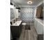 Full bathroom featuring washer, dryer, shower with curtain, modern vanity, and woodgrain flooring at 1206 Mcdougal St, Indianapolis, IN 46203