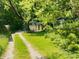 Long driveway leading to a detached garage surrounded by lush greenery at 1206 Mcdougal St, Indianapolis, IN 46203