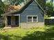 Exterior front view showcasing the blue siding, a covered porch, and maintained lawn at 1206 Mcdougal St, Indianapolis, IN 46203