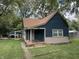 Charming blue home featuring a covered porch and well-maintained lawn surrounded by mature trees at 1206 Mcdougal St, Indianapolis, IN 46203