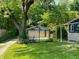 Garage with a basketball hoop and court in the backyard, surrounded by mature trees at 1206 Mcdougal St, Indianapolis, IN 46203