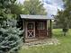Exterior view of a red shed with a metal roof and small porch, surrounded by trees and grass at 1206 Mcdougal St, Indianapolis, IN 46203