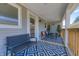Inviting covered porch with stylish black seating and a geometric patterned rug, creating a cozy outdoor space at 1209 Cottage Ave, Indianapolis, IN 46203