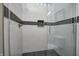 Modern shower stall with black and white tiles, glass enclosure, and rain shower head at 1209 Cottage Ave, Indianapolis, IN 46203