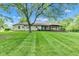 Spacious backyard featuring mature trees and a cozy outdoor seating area on a covered porch at 12121 East 21St St, Indianapolis, IN 46229