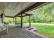 Picturesque covered deck featuring wood flooring and supports, with seating and steps leading to the backyard at 12121 East 21St St, Indianapolis, IN 46229