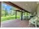 Expansive covered deck showcasing wooden beams, outdoor dining set, and a serene view of the lush green backyard at 12121 East 21St St, Indianapolis, IN 46229