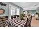 Cozy dining room features a checkered tablecloth, white sheer curtains, and an adjacent sitting area at 12121 East 21St St, Indianapolis, IN 46229