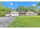 Charming ranch home featuring stone accents, attached garages, well-maintained lawn, and mature trees at 12121 East 21St St, Indianapolis, IN 46229