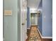 Hallway with neutral colors, wood floors, and a patterned runner, creating a welcoming transition space at 12121 East 21St St, Indianapolis, IN 46229