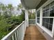 Cozy covered balcony with wood flooring and white railing overlooking greenery and trees at 1280 Shadow Ridge Rd, Indianapolis, IN 46280