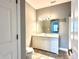 Bathroom with modern vanity, large mirror, and warm tile flooring; illuminated by modern lighting at 1280 Shadow Ridge Rd, Indianapolis, IN 46280