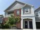 Charming brick and siding townhome with covered porch and blue doors under a clear blue sky at 1280 Shadow Ridge Rd, Indianapolis, IN 46280