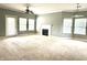 Bright living room featuring neutral carpet, a cozy fireplace, and a door to the patio at 1280 Shadow Ridge Rd, Indianapolis, IN 46280