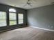 Spacious bedroom with large windows, neutral walls, and carpet, illuminated by a ceiling fan at 1280 Shadow Ridge Rd, Indianapolis, IN 46280