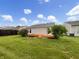 Backyard view featuring wooden deck, lush lawn, and privacy fence under a partly cloudy sky at 13094 N Etna Green Dr, Camby, IN 46113