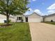 Charming single-story home with a well-maintained lawn and attached two-car garage on a sunny day at 13094 N Etna Green Dr, Camby, IN 46113