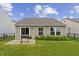 Backyard view with patio, sliding glass door, grill and manicured lawn at 1313 Kenwood Dr, Greenwood, IN 46143