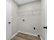 The laundry room offers wood-look flooring and a wire shelf for storage at 1313 Kenwood Dr, Greenwood, IN 46143