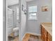 Bright bathroom featuring a vanity with storage, toilet, shower, and natural light from a window at 13766 Heatherfield Dr, Fishers, IN 46038