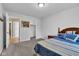 Carpeted bedroom features a bed with blue accents and convenient access to closet and hallway at 13766 Heatherfield Dr, Fishers, IN 46038
