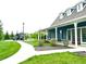 Blue clubhouse exterior showcasing a covered porch and inviting walkway to the playground at 13766 Heatherfield Dr, Fishers, IN 46038