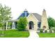 Charming blue clubhouse with stone accents, a fireplace, and well-maintained landscaping at 13766 Heatherfield Dr, Fishers, IN 46038