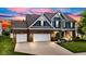 Beautiful two-story home featuring a three-car garage and well-manicured lawn at dusk at 13766 Heatherfield Dr, Fishers, IN 46038