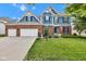 Charming two-story home with a brick and blue siding, lush lawn, and a three-car garage at 13766 Heatherfield Dr, Fishers, IN 46038