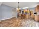 Open kitchen featuring hardwood floors, light wooden cabinetry, a kitchen island with seating and stainless steel appliances at 13766 Heatherfield Dr, Fishers, IN 46038