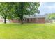 Charming single-story brick home with a well-maintained lawn and mature trees providing shade at 1514 Bittersweet Dr, Greenfield, IN 46140