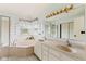 Bright bathroom featuring a double sink vanity, a soaking tub and decorative wall pieces at 15409 Heath Cir, Westfield, IN 46074