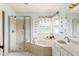 Bathroom with a double sink vanity, a glass enclosed shower, and a separate tub under a window at 15409 Heath Cir, Westfield, IN 46074