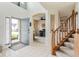 Bright foyer featuring tile flooring, staircase with wooden banister, and view to the living room at 15409 Heath Cir, Westfield, IN 46074