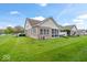The home's backyard offers a large lawn, and established landscaping, creating a private, park-like setting for outdoor enjoyment at 1905 Persimmon Grove Dr, Indianapolis, IN 46234