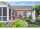 Charming outdoor patio with a screened in porch, dining area, grill, and beautiful landscaping at 1905 Persimmon Grove Dr, Indianapolis, IN 46234