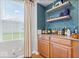 This bar area includes liquor storage, wood cabinets, and a view of the backyard at 1905 Persimmon Grove Dr, Indianapolis, IN 46234
