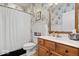 Well-decorated bathroom features wood cabinets, stylish mirrors, and patterned wallpaper at 1905 Persimmon Grove Dr, Indianapolis, IN 46234