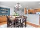 Open-concept dining room featuring a dark wood table set, chandelier, and adjacent kitchen area at 1905 Persimmon Grove Dr, Indianapolis, IN 46234